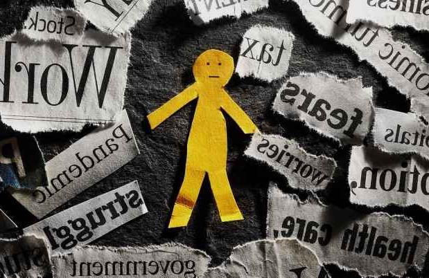 Paper cutout person with words like torn from newspapers