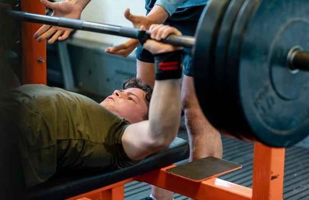 Teen lifting weights on a bench press