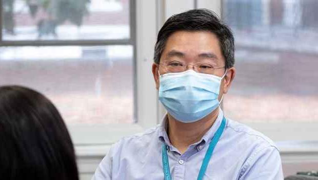 Clinician in mask talks to patient